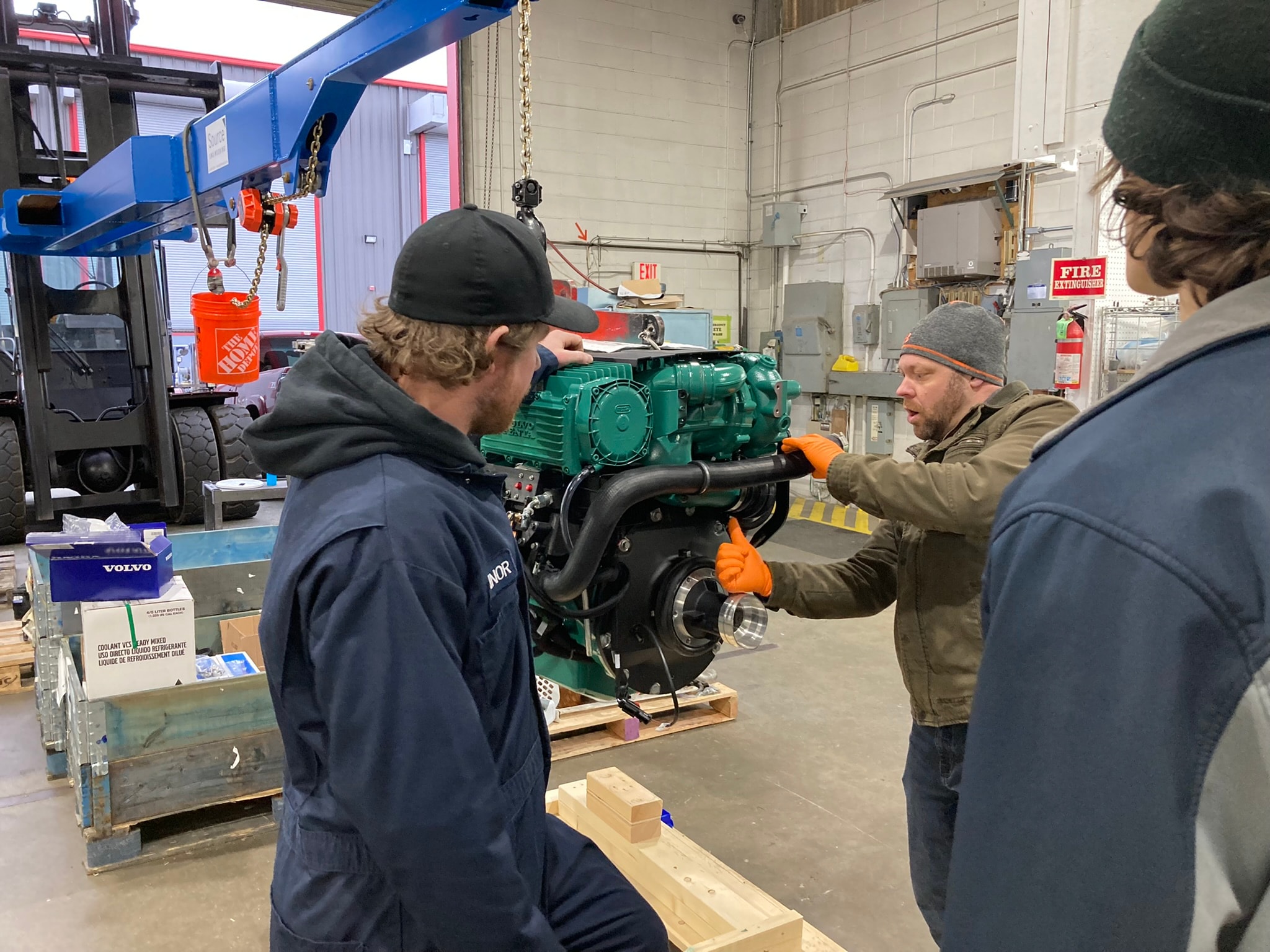 NHD technicians inspecting new Volvo Penta diesel engine on shop floor