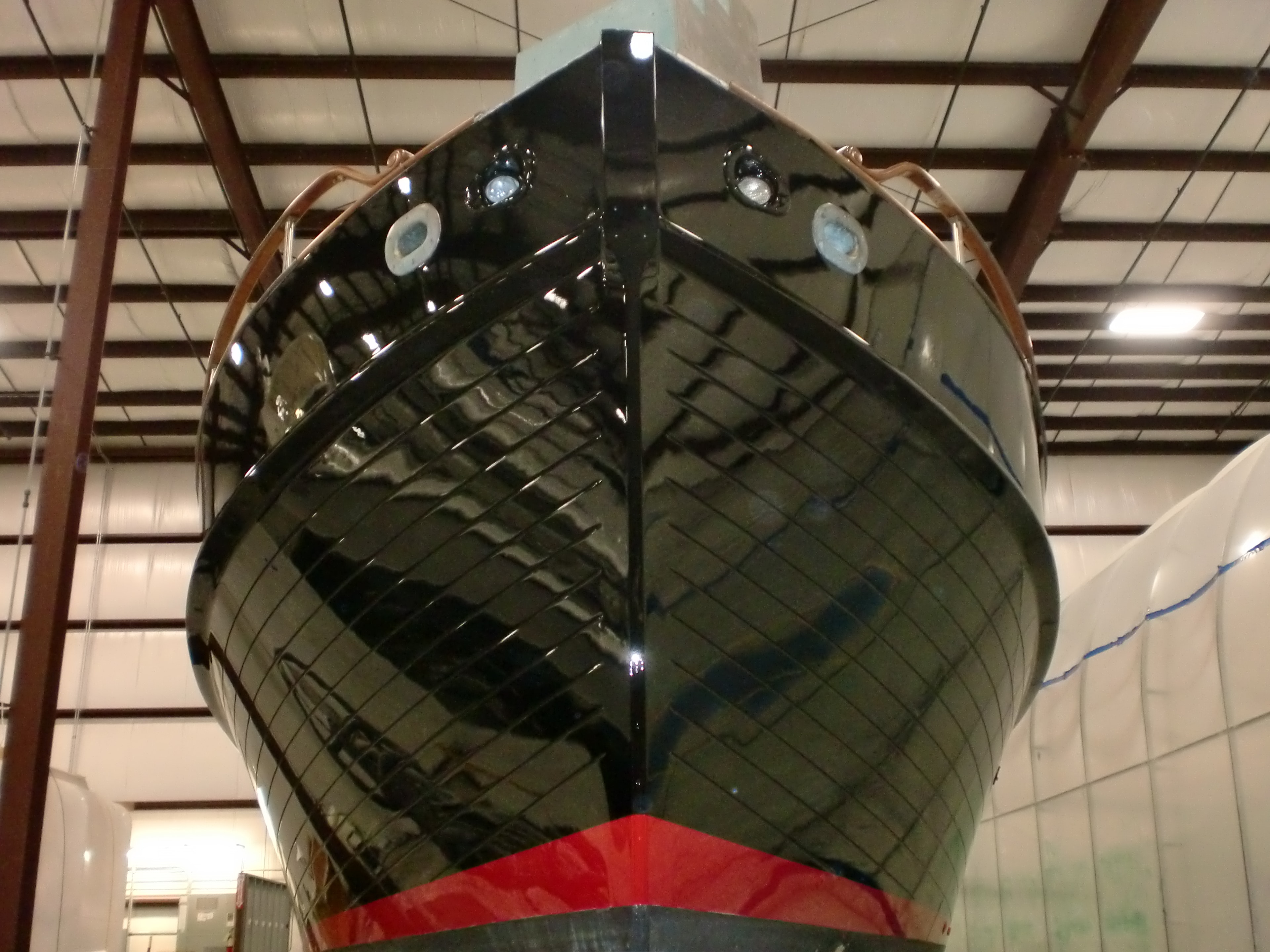 Stunning gloss black custom paint job on yacht bow inside NHD facility