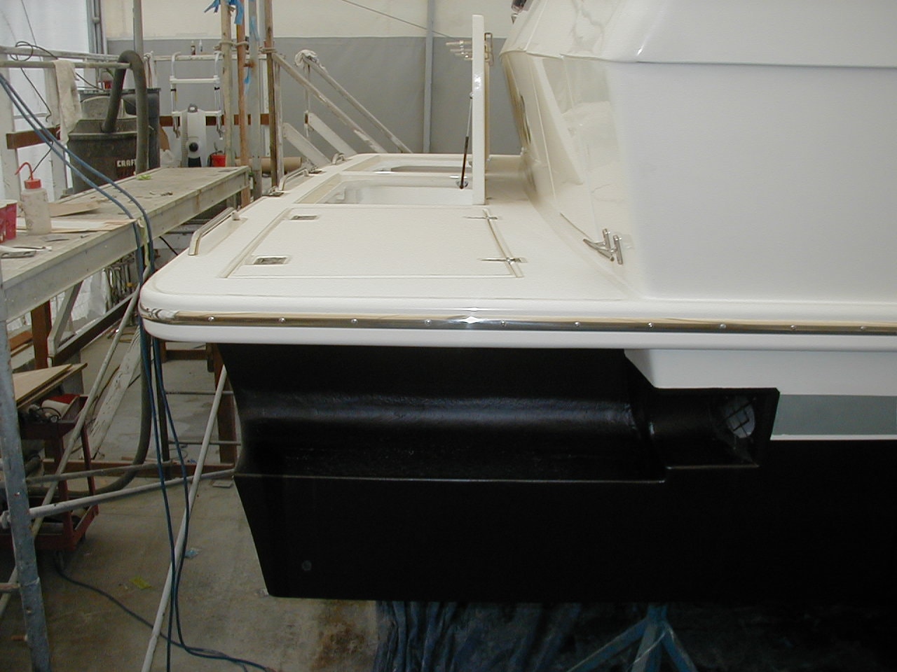 Custom hull extension and fresh paint on motor yacht in NHD shop