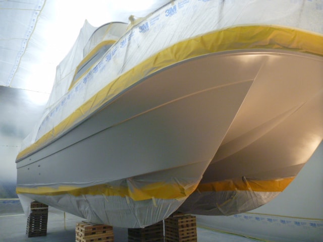 Sea Bear catamaran with fresh grey hull paint applied in NHD enclosed paint facility