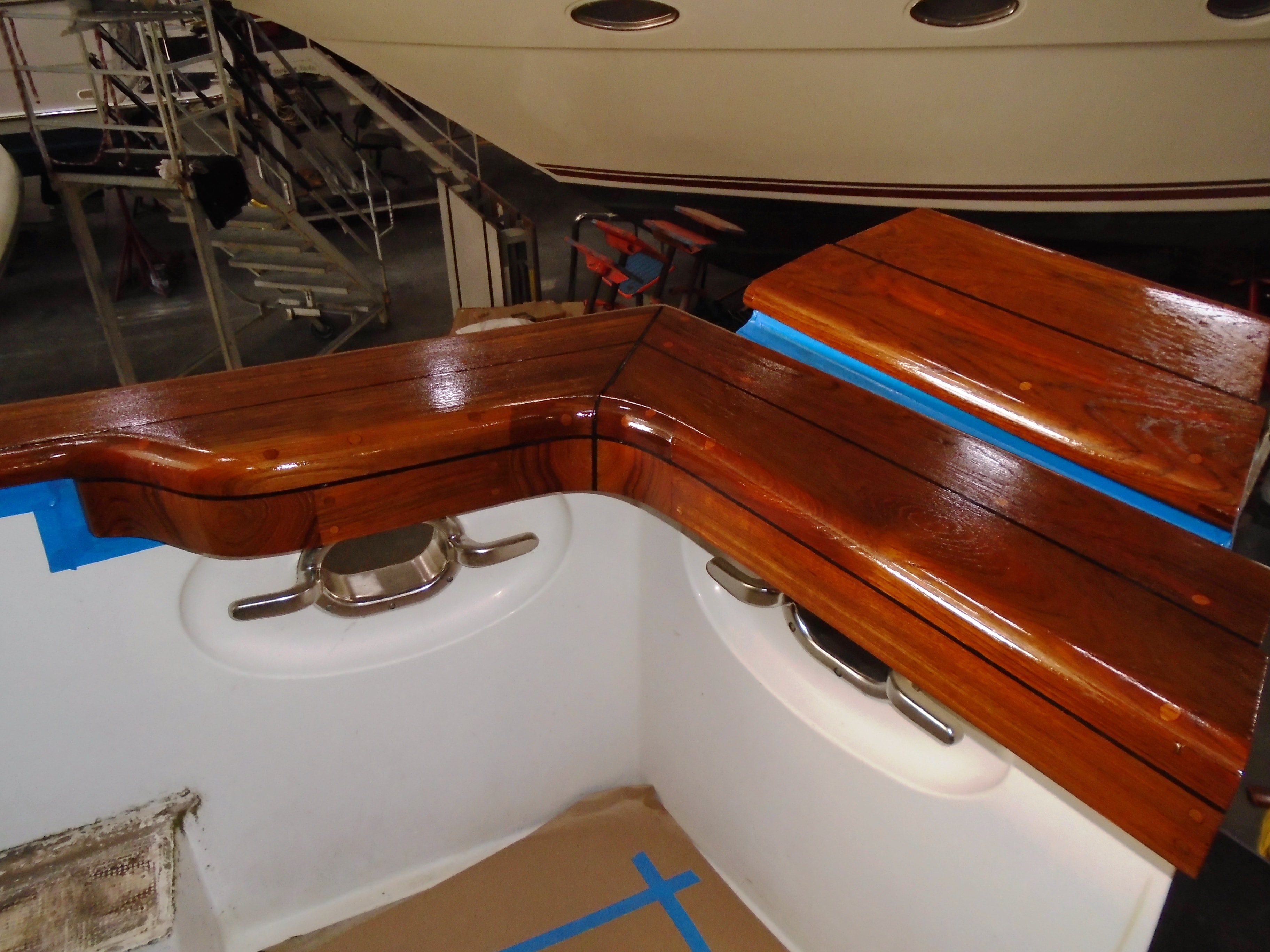 Gleaming varnished teak cockpit coaming and swim step after refinishing at NHD